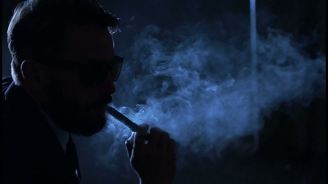 man smoking e-cigarette wearing suit