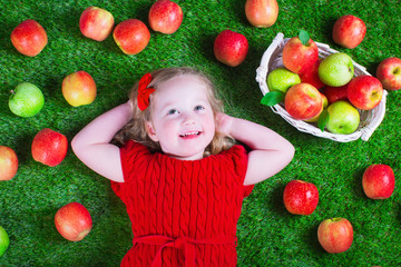 Fototapeta na wymiar Little girl eating apples