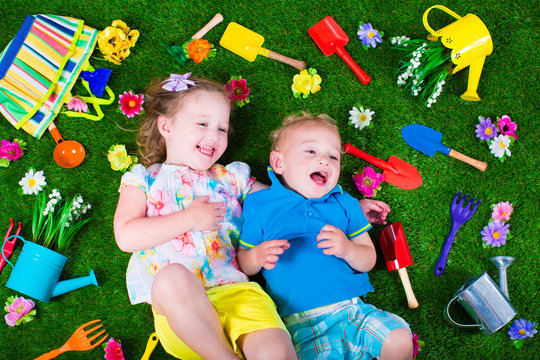 Kids on a lawn with garden tools
