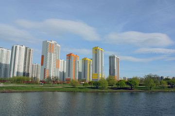 Fototapeta na wymiar multi-storey houses on the lake in the park