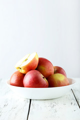 Naklejka na ściany i meble Apples in bowl on white wooden background