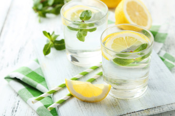 Fresh lemonade with lemon on white wooden background