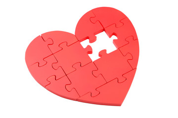 Red puzzle heart isolated on white