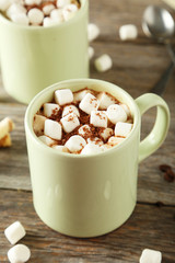 Cup of hot chocolate with marshmallows on grey wooden background