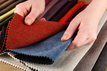 Woman chooses scraps of colored tissue on table close up