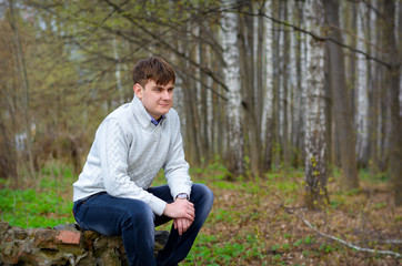 Naklejka na ściany i meble fellow a man sits on a stone in-field and looks