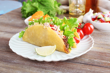 Fototapeta na wymiar Tasty taco with vegetables on plate on table close up