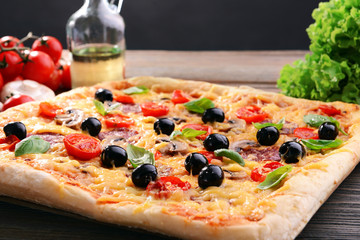 Delicious homemade pizza on table on black background