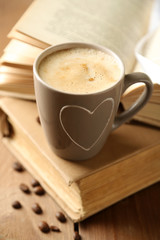 Still life with cup of coffee and books, on wooden table
