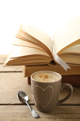 Still life with cup of coffee and books on wooden table, on white background