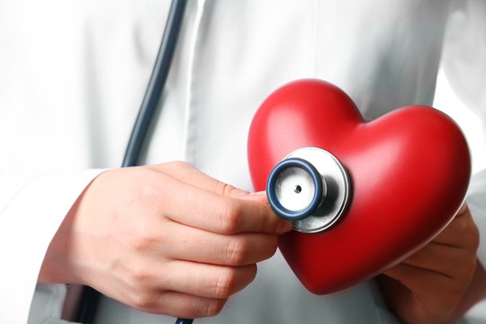 Doctor hands with stethoscope and red heart, closeup