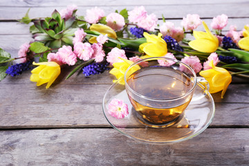 Cup of herbal tea with flowers on wooden background