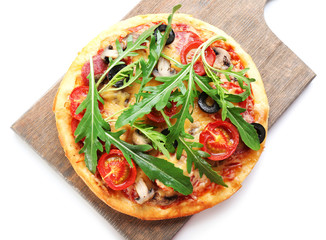 Tasty pizza with vegetables and arugula on cutting board isolated on white