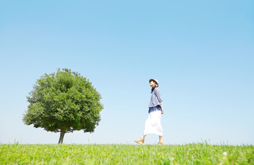 原っぱを散歩する女性