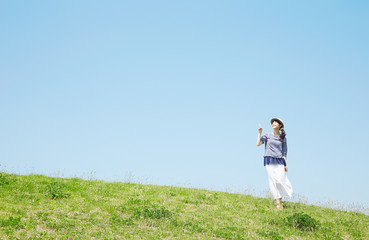 丘で指差す女性