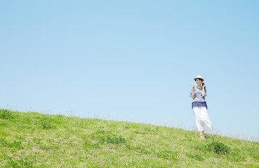 丘でガッツポーズする女性