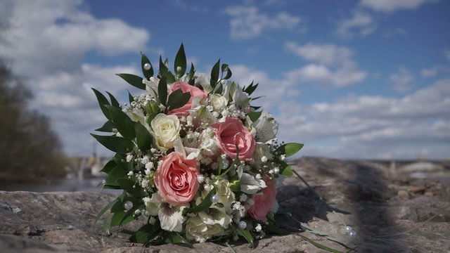 Wedding Bouquet On The Stone. Cloudy Sky Background
