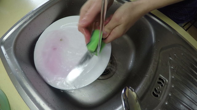 hands wash knife and dish under water in kitchen sink. 4K