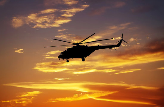 Picture of helicopter at sunset. Silhouette of helicopter on sun