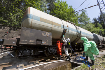 Naklejka premium Toxic chemicals acids emergency team near train