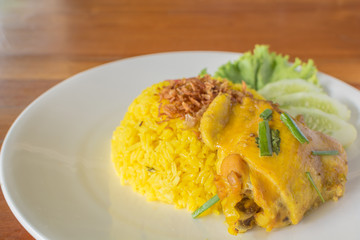 Biryani chicken yellow on a white plate.