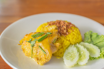 Biryani chicken yellow on a white plate.
