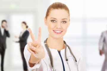 Medical doctor woman gesturing victory.