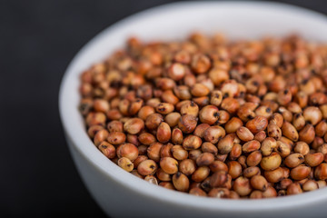 Sorghum in a white bowl on a black background