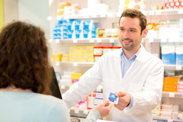 Fototapeta premium Attractive pharmacist taking healt credit card