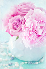 Floral composition with a pink peony and roses in a vase. 