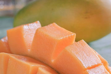 Ripe mango with slices on banana leaves