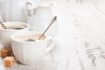 Obraz na płótnie Canvas Cup of coffee with sugar cubs and milk jug
