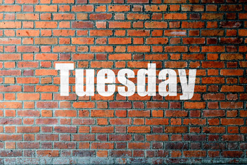 Red Brick wall texture with a word Tuesday