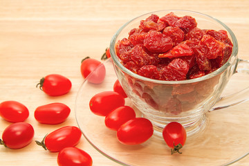 Dried tomatoes in glass on wooden background