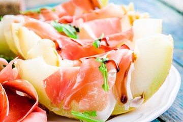 salad of melon with thin slices of prosciutto closeup