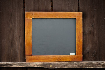 Vintage slate chalk board hanging on wooden background