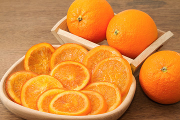 Dried orange slices nad fresh orange on wooden background