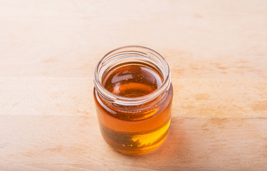 Honey in a mason jar on a wooden background