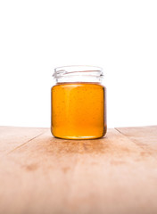 Honey in a mason jar on a wooden background