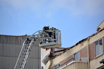 bomberos trabajando en la cornisa de un edificio