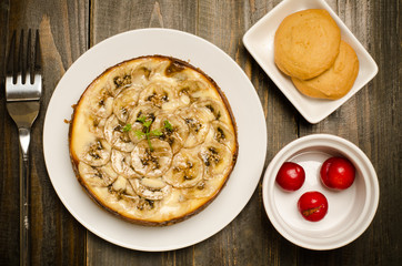 Banana caramel cheesecake on wooden background