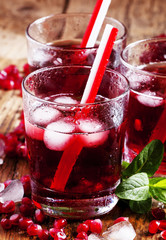 Fresh red juice cocktail with pomegranate seeds, mint and ice, s