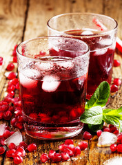 Fresh red juice cocktail with pomegranate seeds, mint and ice, s