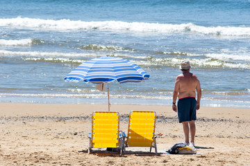 Mann am Strand, schaut aufs Meer
