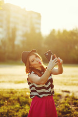 Lovely girl in a hat on the street makes Selfei