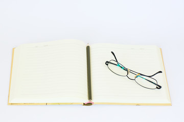 Open blank notebook with glasses and pencil on the top