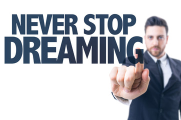 Business man pointing the text: Never Stop Dreaming