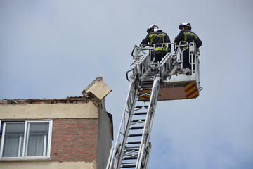 bomberos trabajando sobre un tejado