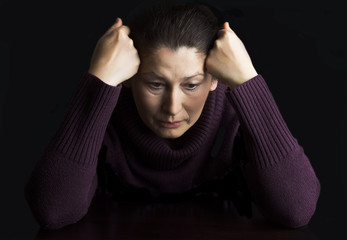 Mature woman in deep sitting  thought  at home.