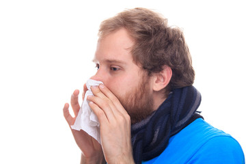 Cold man sneezing in the handkerchief